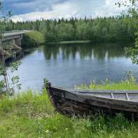 scenic river, canoe on bank & bridge